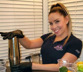 Professional Female beautiful bartender holding a shaker at Bartenders Vip Mix event
