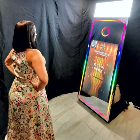 Elegant mirror photo booth with touchscreen display, frame lighting, and a red carpet setup, ready for guests at a stylish event.